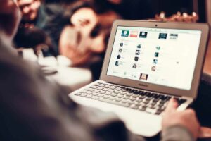 Person using a laptop with various apps on screen, enhancing productivity with Elevate Your Organization's Culture and Performance With CEEK.