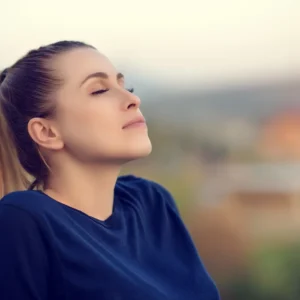 Woman enjoying peaceful moment outdoors, reflecting relaxation and mindfulness, only available at Elevate Your Organization's Culture and Performance With CEEK.