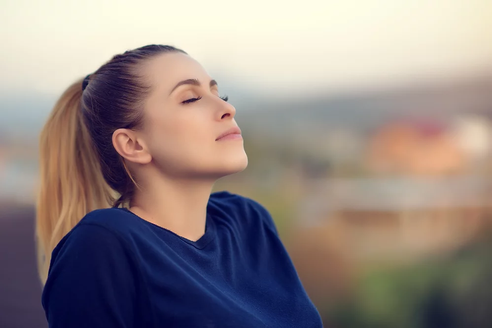 Woman enjoying peaceful moment outdoors, reflecting relaxation and mindfulness, only available at Elevate Your Organization's Culture and Performance With CEEK.