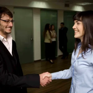 Business professionals shaking hands in an office setting, enhancing culture and performance, only available at Elevate Your Organization's Culture and Performance With CEEK.