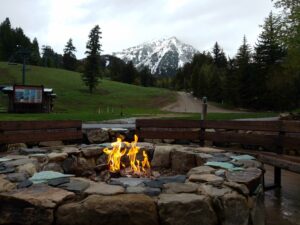Stone fire pit with mountain view at a scenic resort, only available at Elevate Your Organization's Culture and Performance With CEEK.
