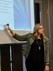 Speaker presenting a program in front of a projector screen, enhancing organizational culture, only available at Elevate Your Organization's Culture and Performance With CEEK.