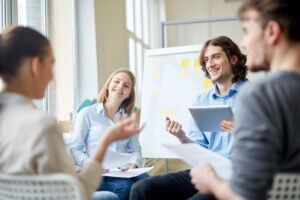 Team collaboration and discussion in a bright office, enhancing culture and performance with Elevate Your Organization's Culture and Performance With CEEK.