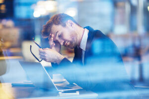 Tired manager at desk, struggling with work stress, only available at Elevate Your Organization's Culture and Performance With CEEK.