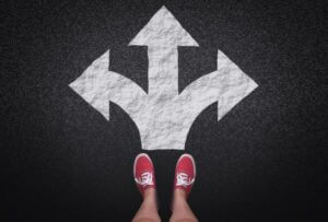 Feet in red sneakers stand before three directional arrows, symbolizing choice and direction, featured by Elevate Your Organization's Culture and Performance With CEEK.