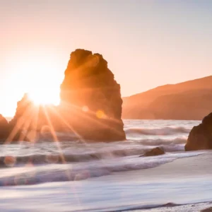 Sunset over ocean rocks with waves, symbolizing tranquility and growth, only at Elevate Your Organization's Culture and Performance With CEEK.