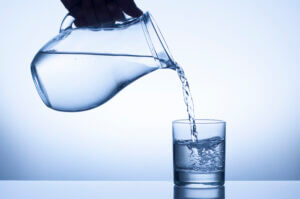 Water pouring from a pitcher into a glass, symbolizing clarity and refreshment, exclusively at Elevate Your Organization's Culture and Performance With CEEK.