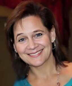 Smiling woman with brown hair and blue eyes, promoting positive work culture at Elevate Your Organization's Culture and Performance With CEEK.