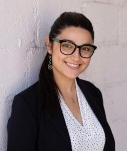 Professional woman smiling in business attire, showcasing team culture and performance strategies, only at Elevate Your Organization's Culture and Performance With CEEK.