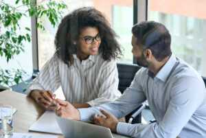 Female trainee smiling at mentor during office meeting, available at Elevate Your Organization's Culture and Performance With CEEK.