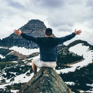 Man embracing mountain scenery with open arms, symbolizing achievement and growth, only at Elevate Your Organization's Culture and Performance With CEEK.