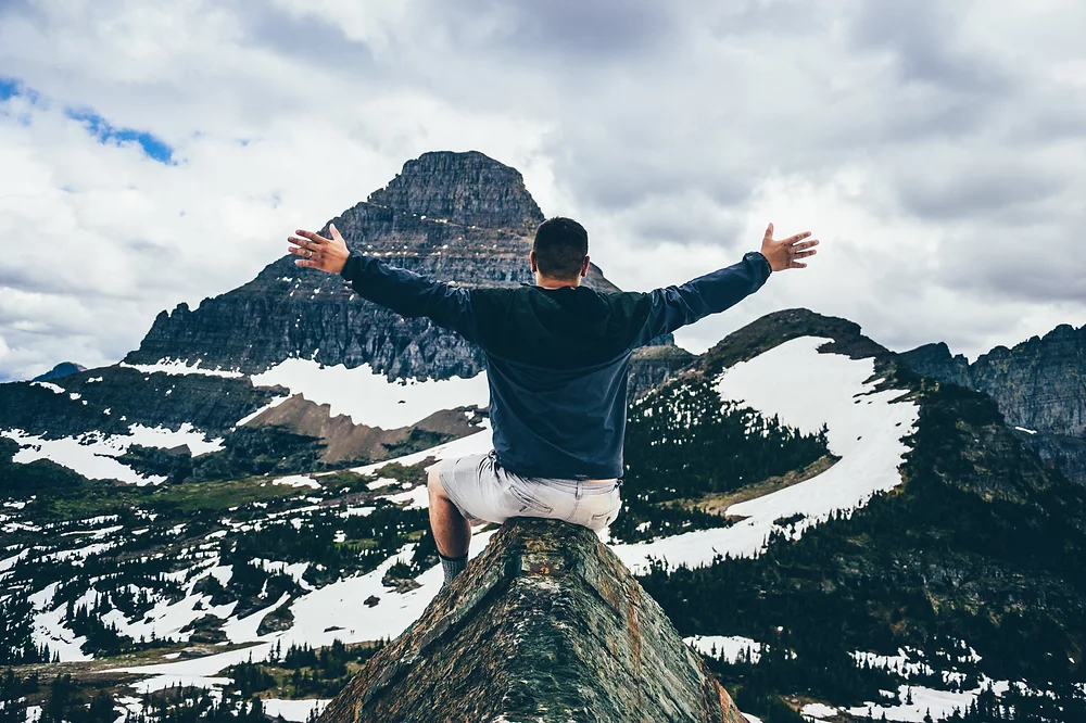 Man embracing mountain scenery with open arms, symbolizing achievement and growth, only at Elevate Your Organization's Culture and Performance With CEEK.