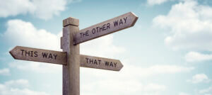 Wooden road sign with arrows pointing 'This Way', 'That Way', 'The Other Way', featured by Elevate Your Organization's Culture and Performance With CEEK.