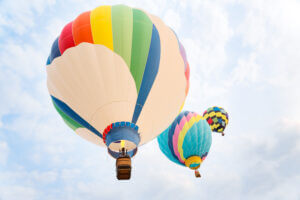 Colorful hot air balloons soaring in a clear sky, symbolizing growth and freedom, only at Elevate Your Organization's Culture and Performance With CEEK.
