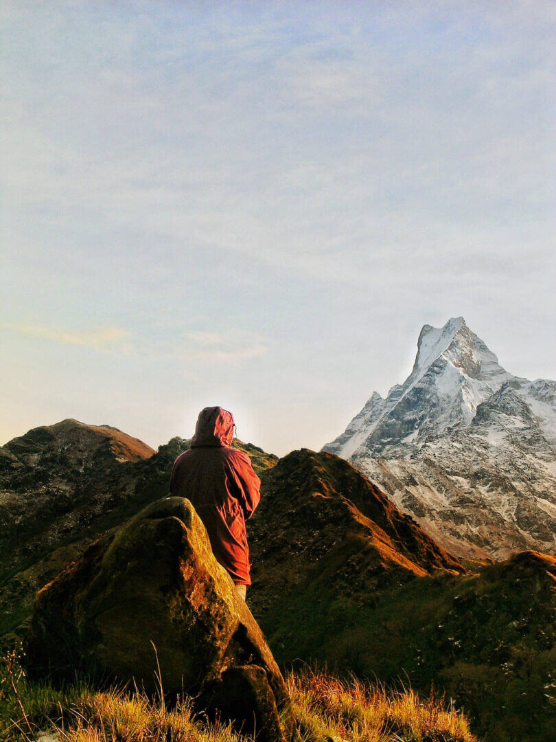 Epic mountain view with a person in a hooded jacket, only available at Elevate Your Organization's Culture and Performance With CEEK.