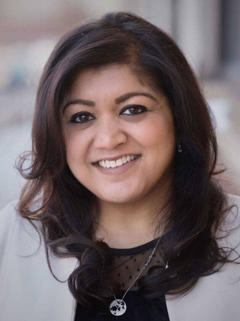 Smiling individual with dark hair, showcasing professional culture, only available at Elevate Your Organization's Culture and Performance With CEEK.