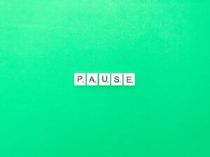 Scrabble tiles spelling "PAUSE" on green background, symbolizing mindfulness, available at Elevate Your Organization's Culture and Performance With CEEK.