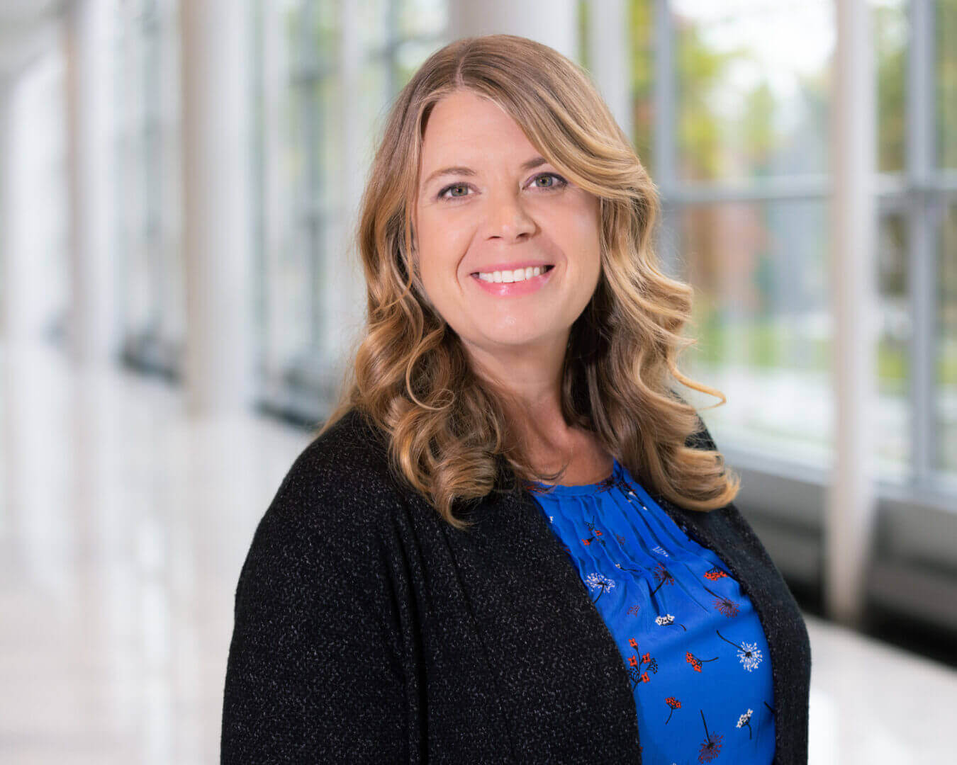 Professional portrait of a smiling woman in a blue blouse, featured at Elevate Your Organization's Culture and Performance With CEEK.