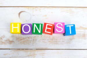 Colorful wooden blocks spelling 'HONEST' on a wooden table, available at Elevate Your Organization's Culture and Performance With CEEK.