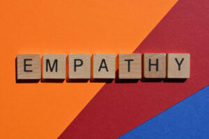 Empathy spelled with wooden blocks on colorful background, enhancing culture at Elevate Your Organization's Culture and Performance With CEEK.