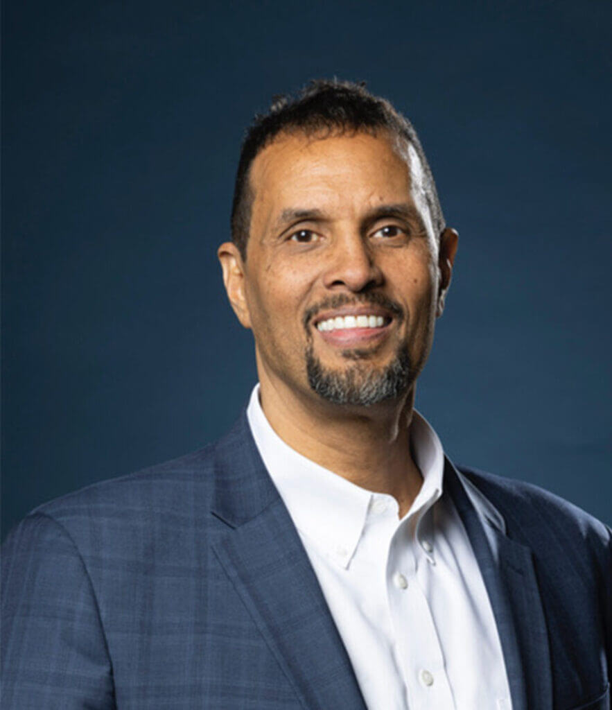 Professional portrait of a smiling man in a suit, enhancing leadership at Elevate Your Organization's Culture and Performance With CEEK.